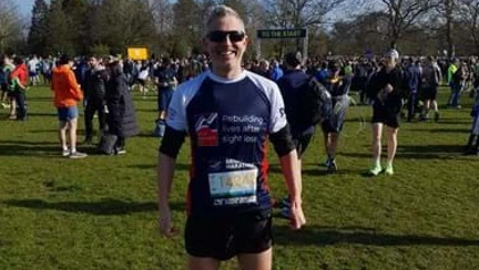 Stuart stood in a field with fellow runners behind him