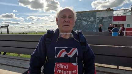 Danny in his Blind Veterans UK t shirt and harness is ready to board the plane