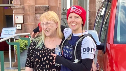 A photo of Star with her arm around her mum, standing in front of the Llandudno centre at the end of the run