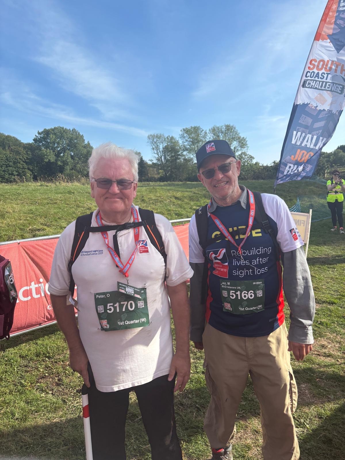 Peter and Jez in Blind Veterans UK T-shirts and Peter holding his white cane