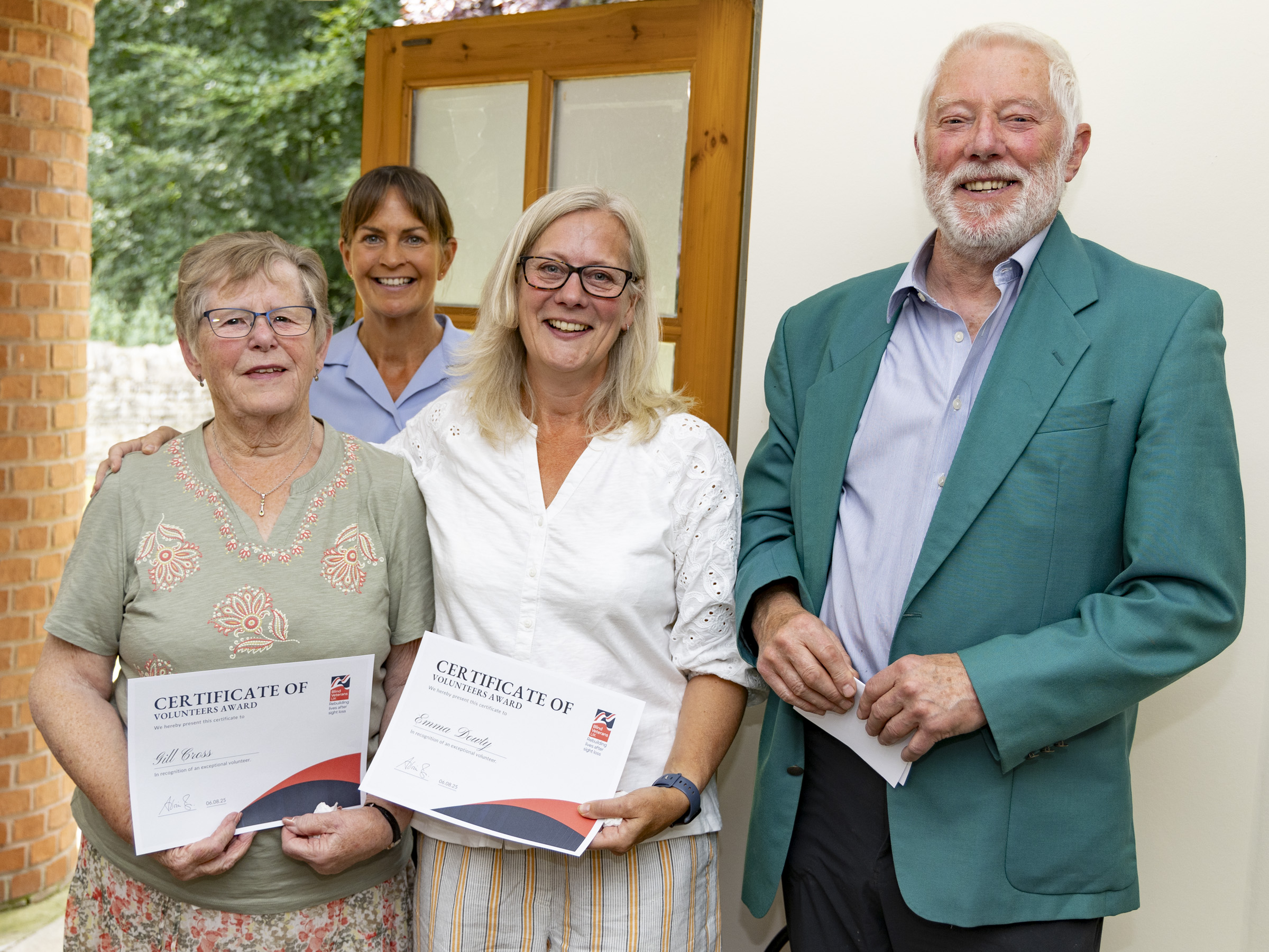 Four people standing together smiling after the Founders Awards ceremony at RAF Carnwell. Volunteers Gill and Emma are holding their certificates, joined by Warrant Officer Tracey, and Russel Hibbins, who nominated them.