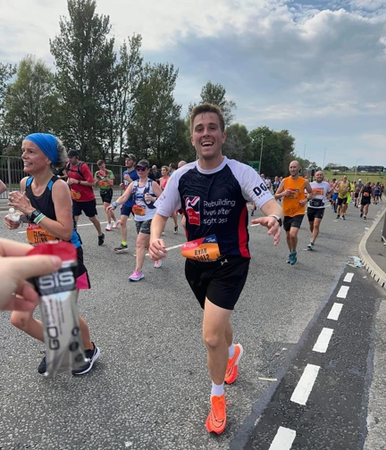 Ryan in action on the race course, smiling as he runs towards the camera.
