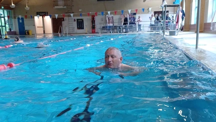 Lee half way down the pool doing breast stroke