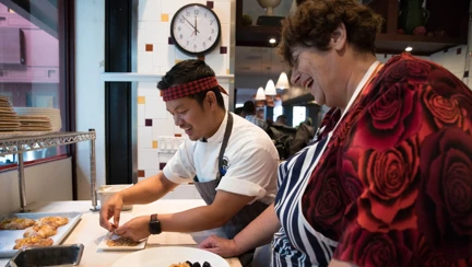 Photo of chef Mack, left, teaching Penny, right, how to make a peach gallete at San Francisco's One Market