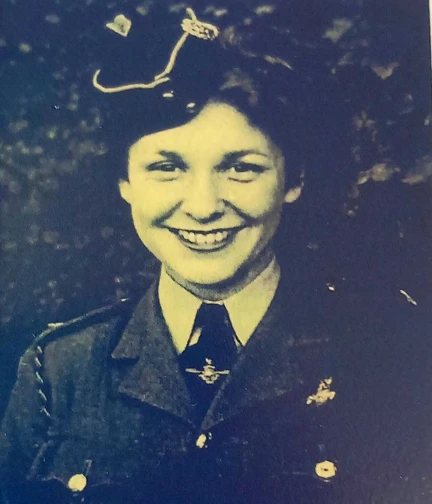 Mary is wearing her uniform, smiling, and looking into the camera