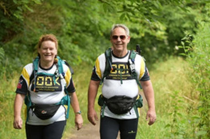 Maria and Richard walking side by side along a country footpath