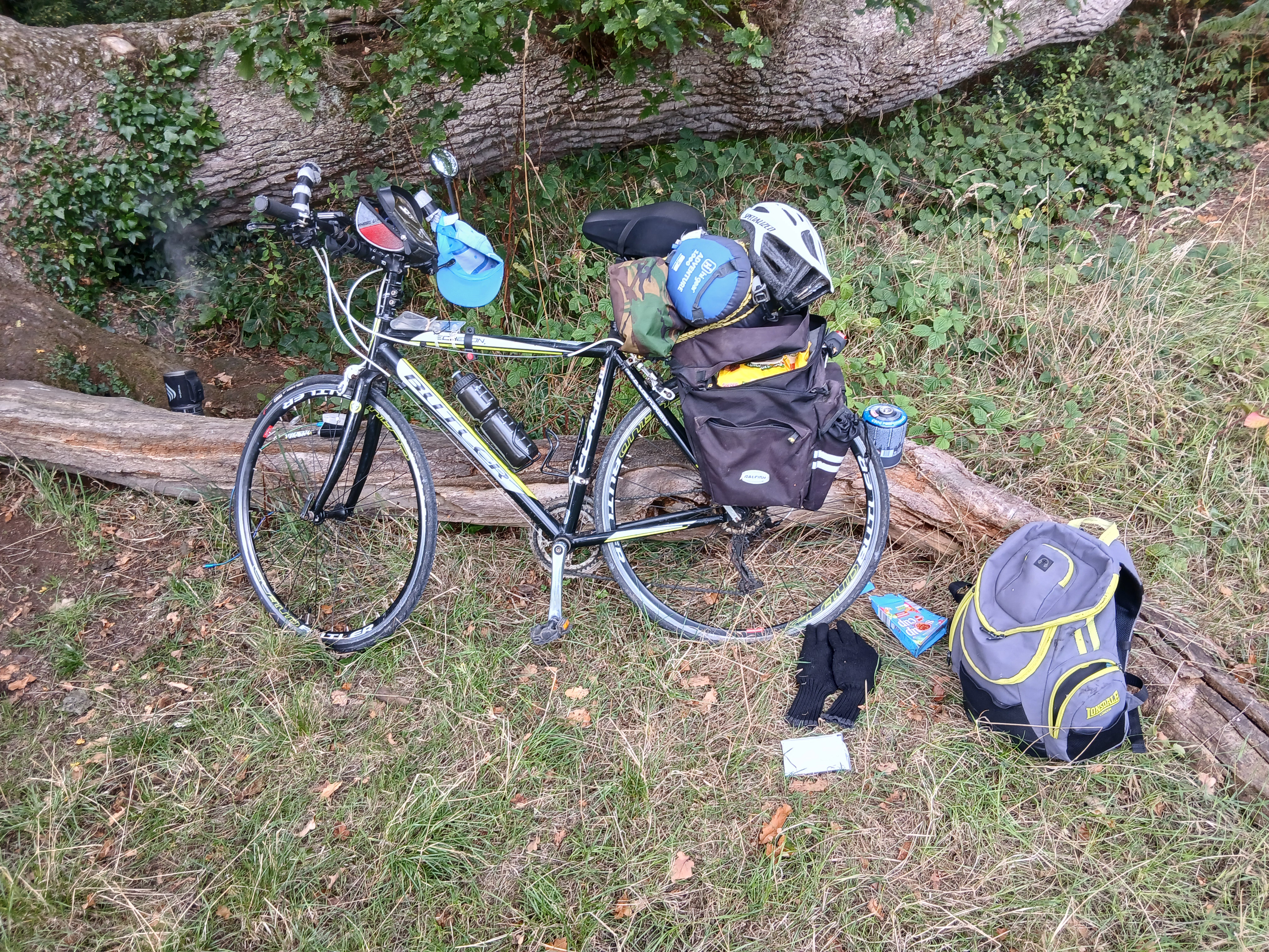 Eddy's bike resting against a log. It's loaded up with everything he needs for the challenge