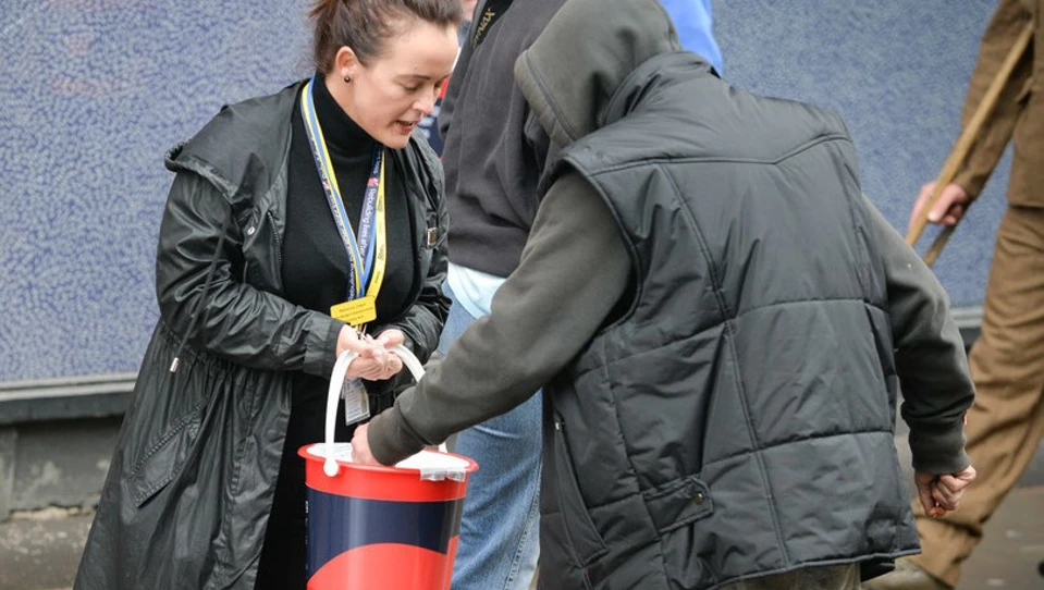Bucket collection taking a donation for Blind Veterans UK.