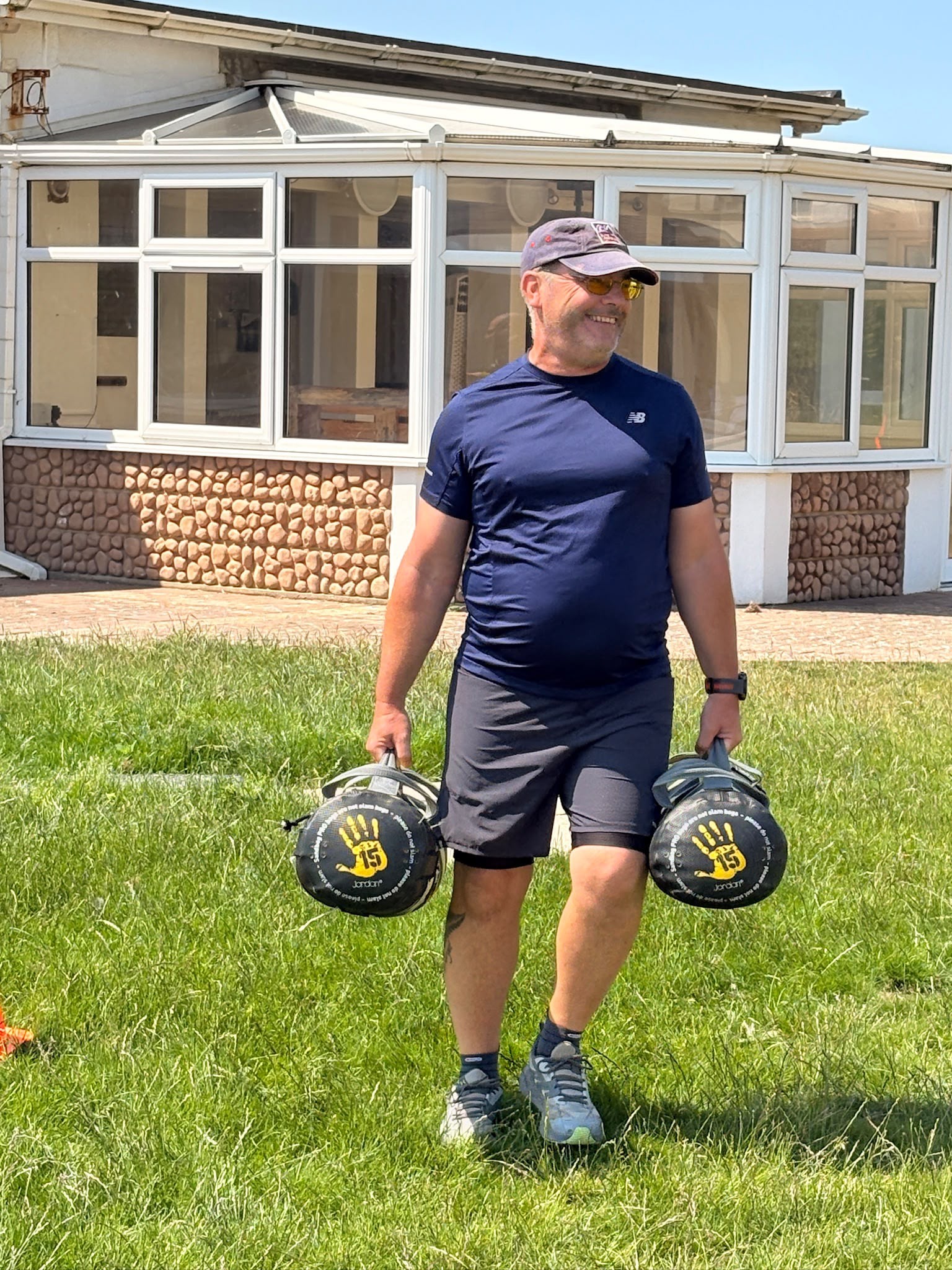 Andy is walking between two cones placed 100 metres apart while carrying a weight bag in each hand