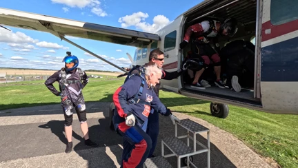 Danny is climbing three metal steps to board the small plane. He is feeling his way with his hands