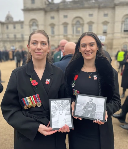 D-Day veteran George Chandler's Granddaughters carrying his photos and marching in his memory