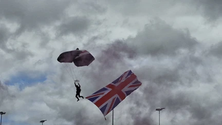 A person parachuting next to a large Union Jack flag