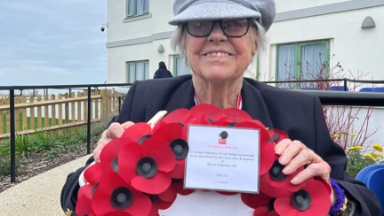 Nancy sat in her wheelchair holding up her wreath and smiling