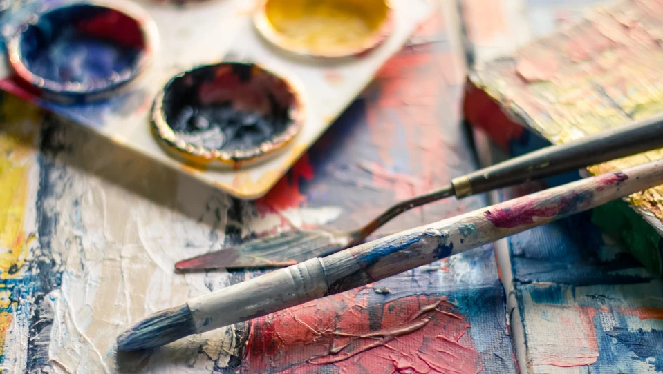 A used paintbrush near paint pallet