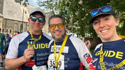 Wayne, Theresa and Rich with their arms around each other and medals around their necks