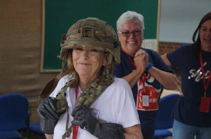 Jennie is wearing civilian clothes with a camo helmet and belt
