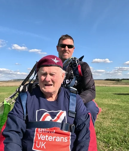 Danny is sat on the ground following landing and is wearing his beret