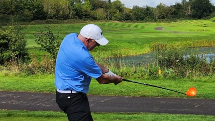 Kevin taking a shot on the golf course