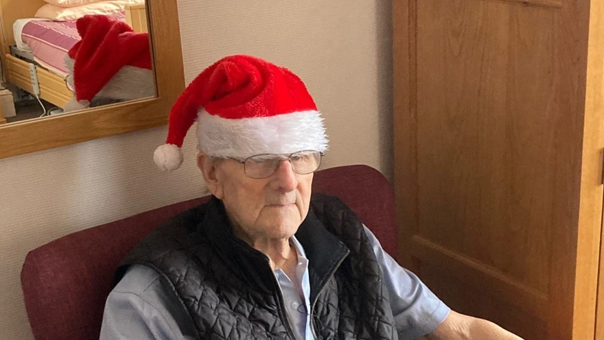 Blind veteran Harry sitting down, wearing a Christmas hat
