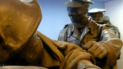 Bronze statue of men in uniform wearing bandages over eyes