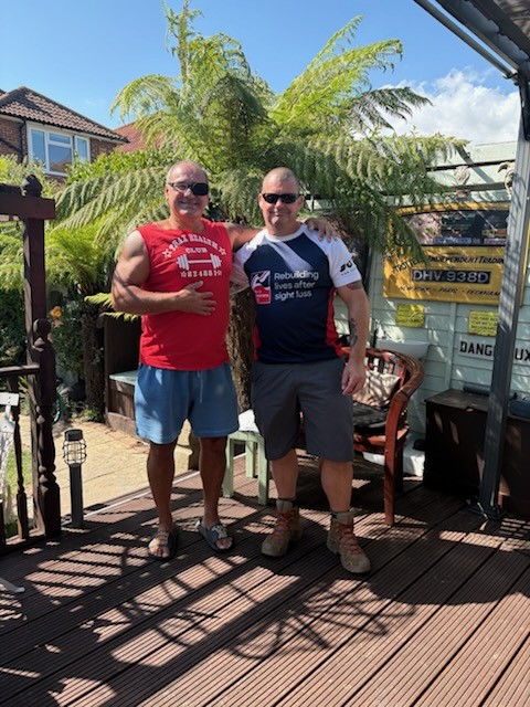 Mike and Stu stood in the sun on wooden decking