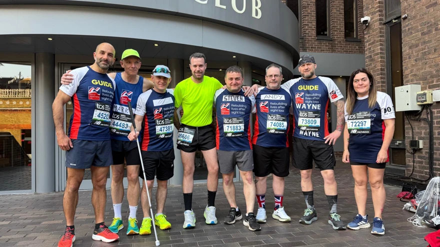 A group photo of our four blind veterans runners and their guides stood outside the Union Jack Club wearing their Blind Veterans UK tops