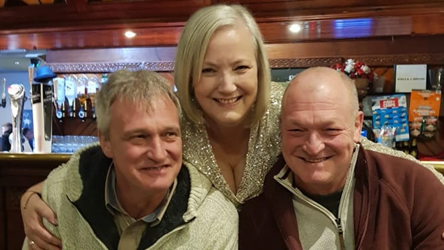 Christine stood between her two brothers and all three are smiling widely