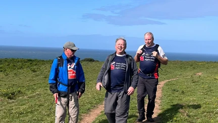 The three men all wearing Blind Veterans UK T-shirts make their way along tyre tracks with Phil slightly ahead with his white cane
