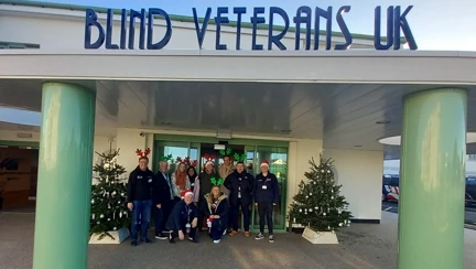 A large group of people in festive attire, standing outside the entrance of the Rustington Centre