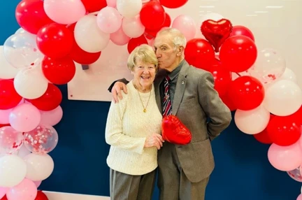 Member Ken kissing his wife, Christine, on the forehead.