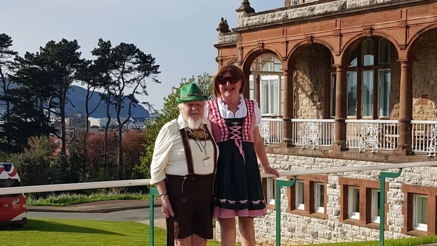 Michelle and Brian wearing German style clothing stood in front of the Llandudno Centre