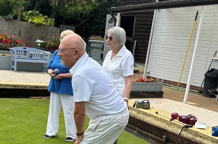 Veteran dressed in white playing bowls on a bowling green