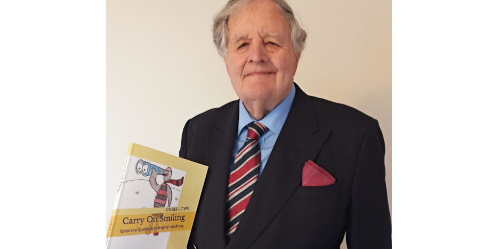 Blind veteran Chris holding up his book 'Carry on Smiling'