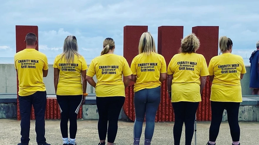 Blind veteran Griff's family, showing the back of their memorial t-shirts displaying text that says: Charity walk in memory of Griff Jones