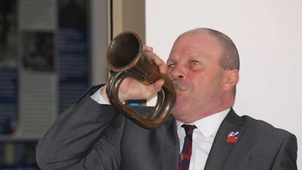 Blind veteran Billy blowing into a trumpet