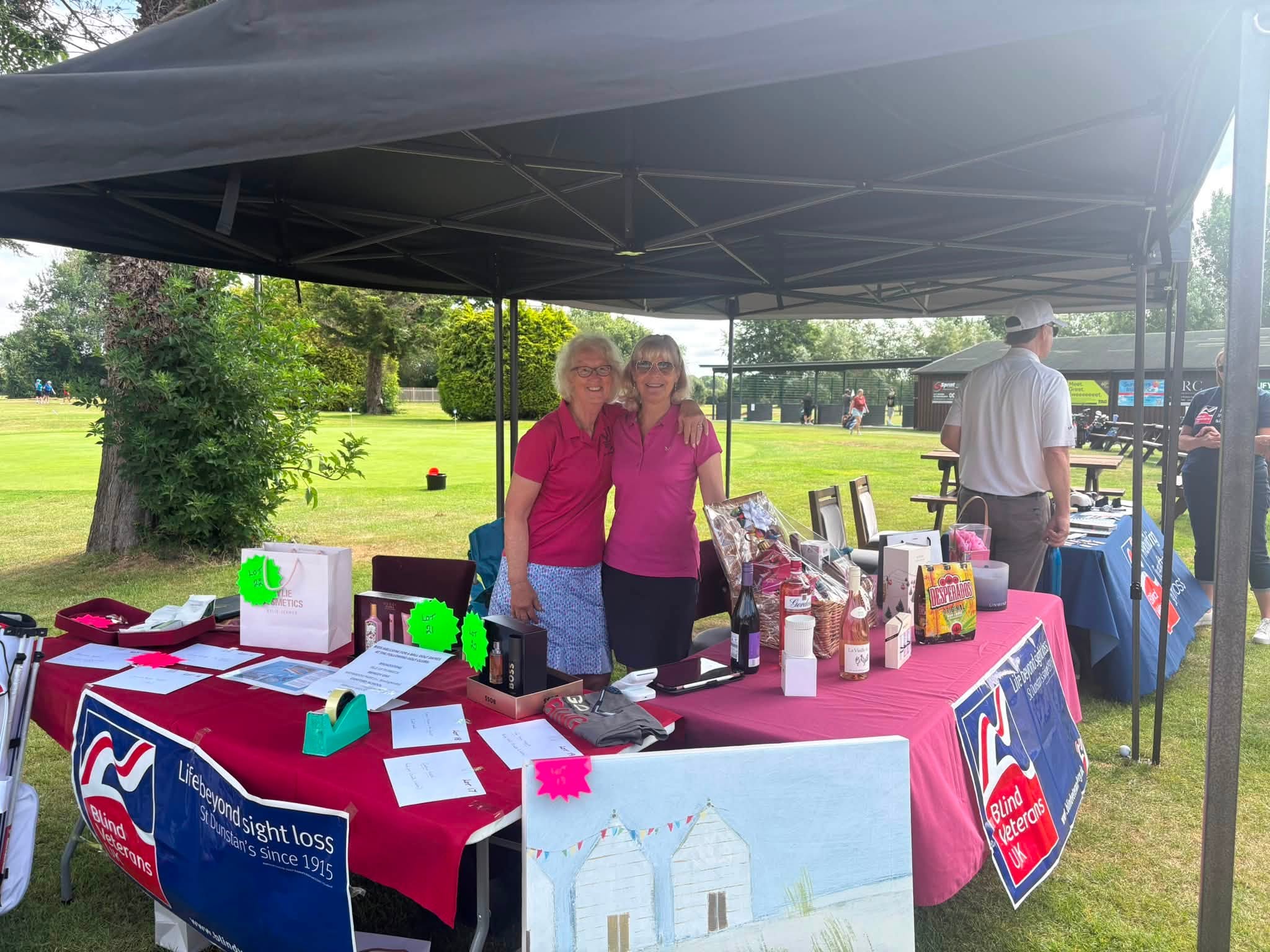 Claire and Zoe are stood at a stand beneath a gazebo 