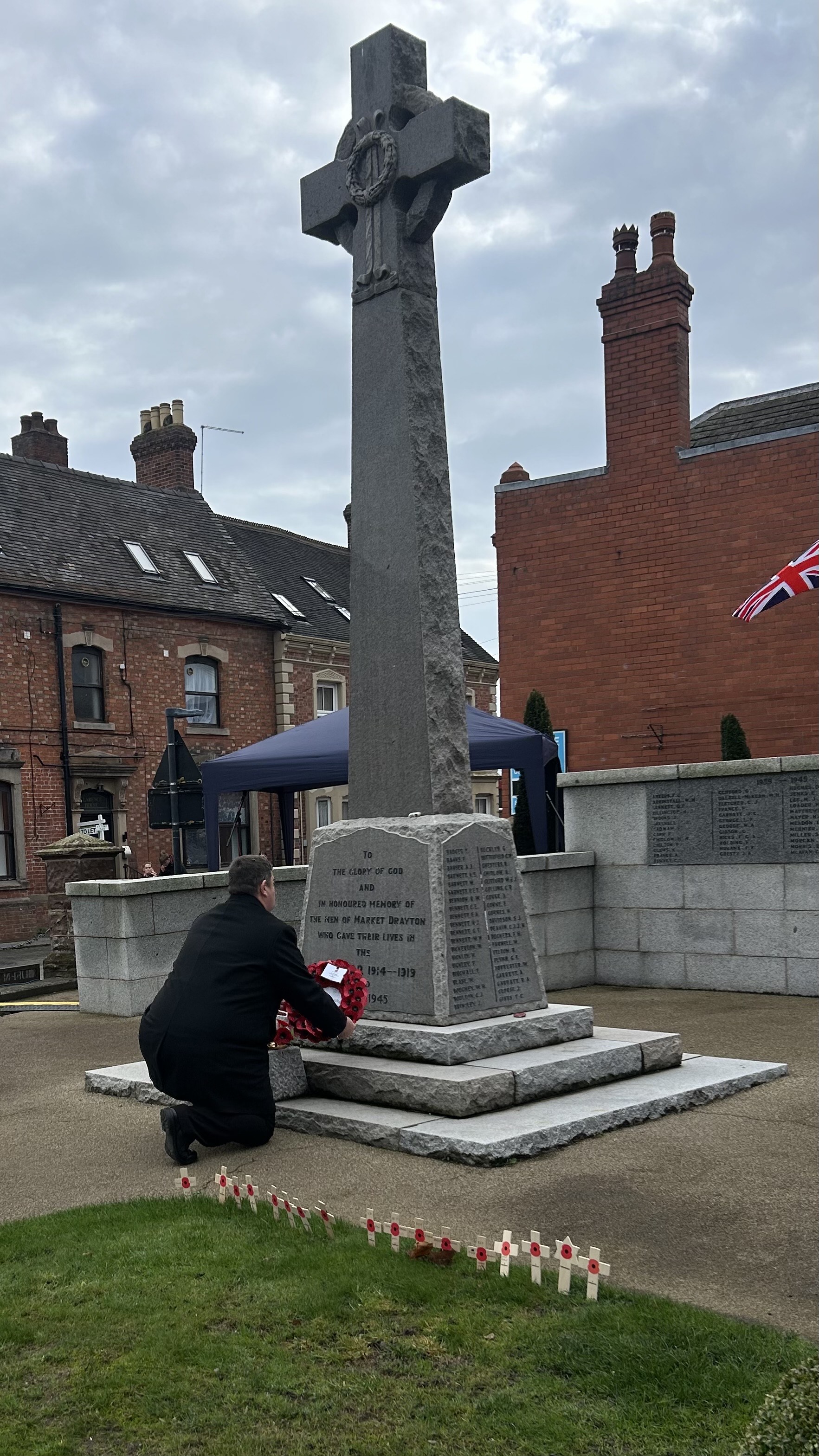 Clive bent at the foot of the war memorial as he places down his wreath