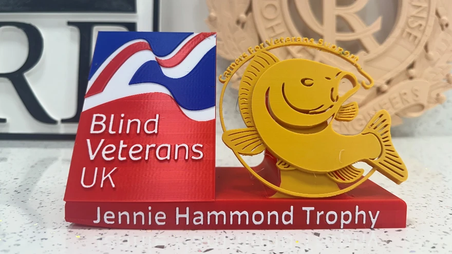 Blind Veterans UK logo on the left, beside a gold silhouette of a carp with text above 'Carpers for Veterans Support' on the right, and text below 'Jennie Hammond Trophy'