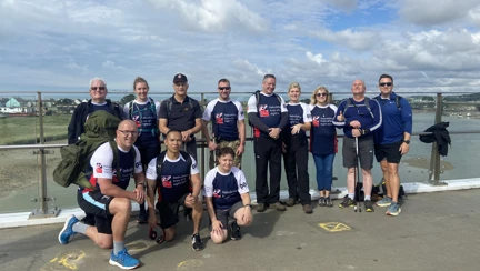 Blind veterans and guides standing by the sea on their 22 mile walk from Ovingdean to Rustington