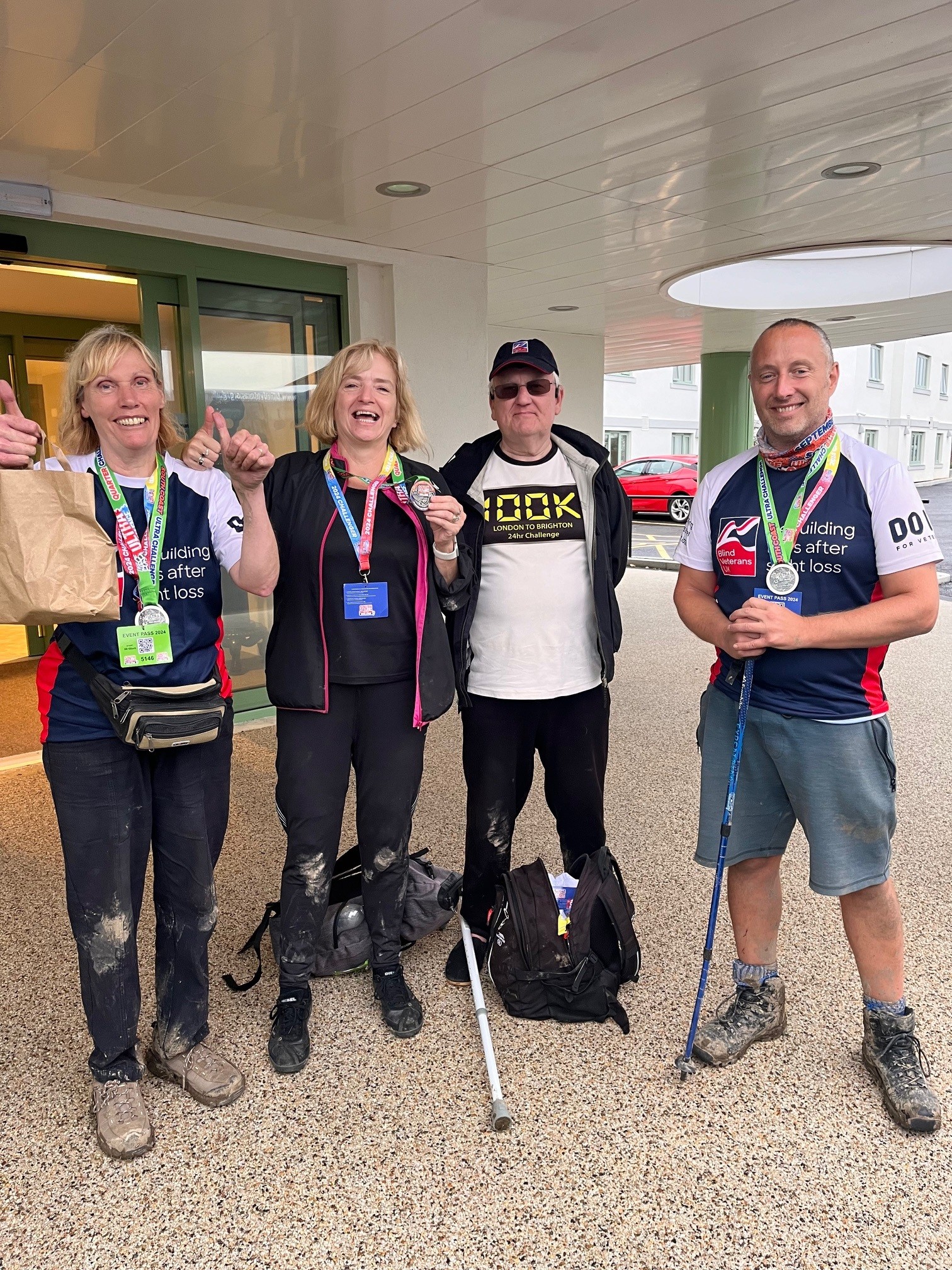 Glynis stands with a group following the challenge, they look happy and give thumbs up