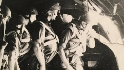 A sepia photograph of Danny with his fellow paratroopers stood at the door to the plane ready to jump