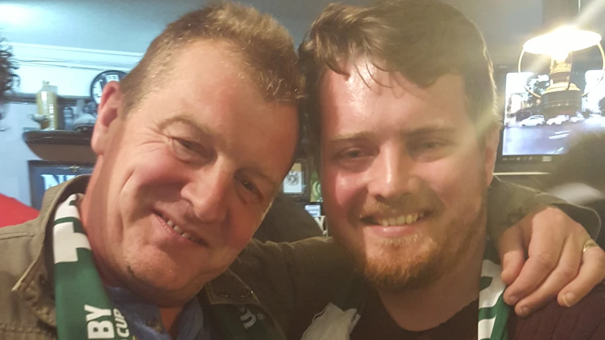 Steve with his arm around Ben while they both hold pints of beer