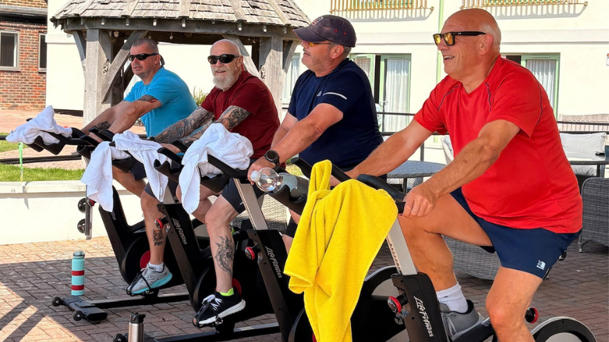 The four blind veterans are lined up on their exercise bikes in the garden at Rustington.