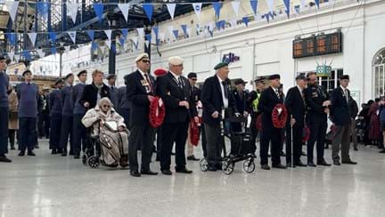 Blind veterans, police officers, RAF veterans and Air cadets who were among those who took part in the parade are stood inside the train station ahead of two minute silence