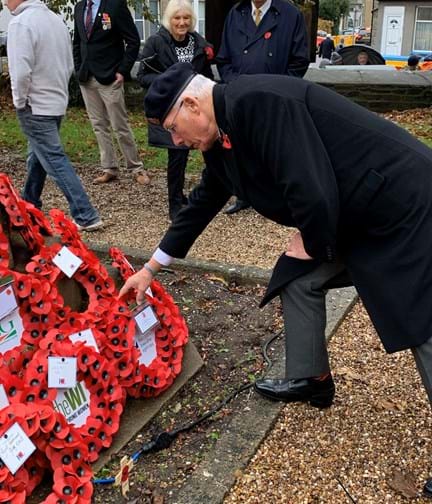 Blind veteran Howell laying a wreath in Porthcawl