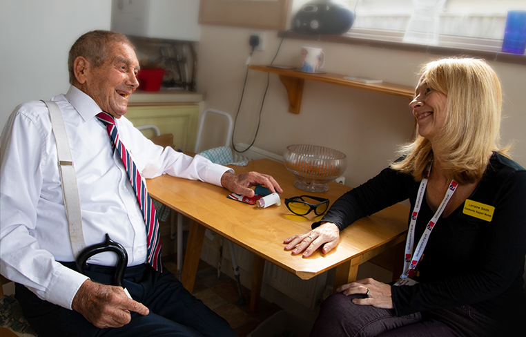 A photo of blind veteran Eddie, left, sharing a laugh with his Blind Veterans UK Community Support Worker, Lorraine