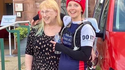 A photo of Star with her arm around her mum, standing in front of the Llandudno centre at the end of the run