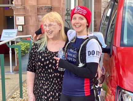 A photo of Star with her arm around her mum, standing in front of the Llandudno centre at the end of the run