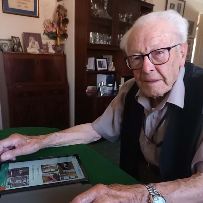 Blind veteran Eddie sitting with his tablet looking at photographs
