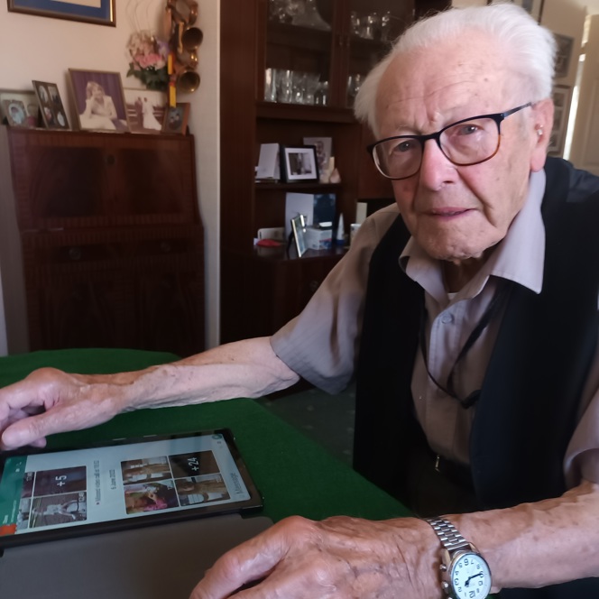 Blind veteran Eddie sitting with his tablet looking at photographs